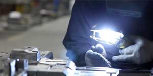 A worker performing detail work on a mold