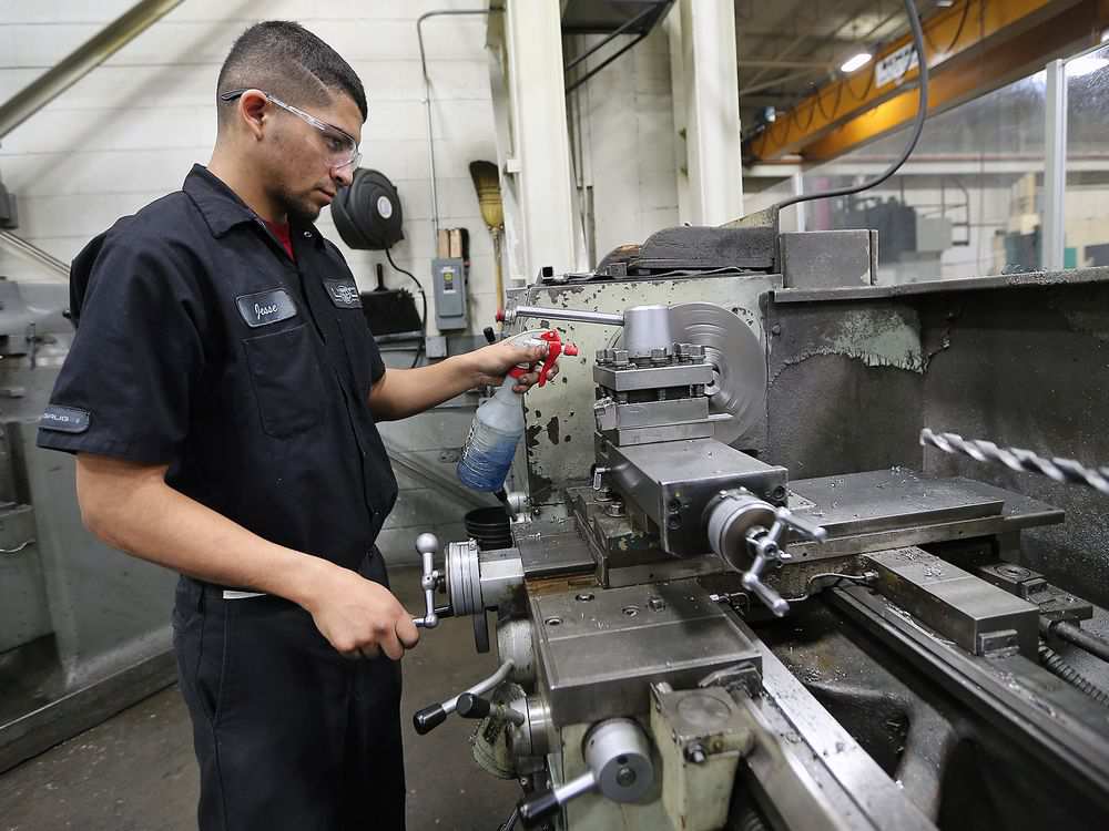 A worker operating a horizontal lathe.